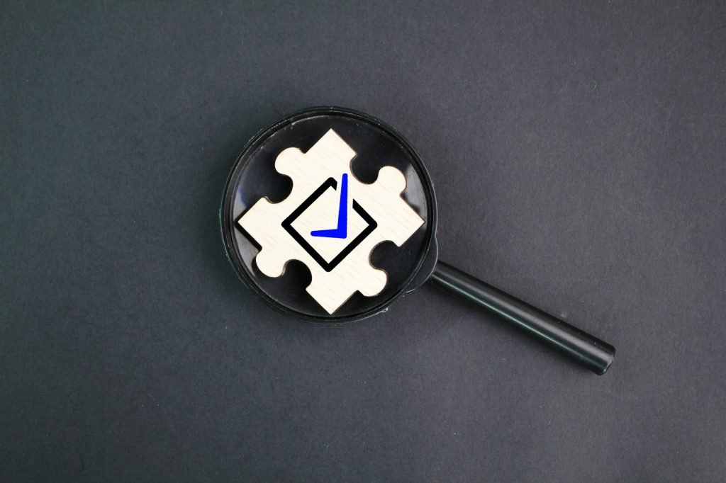 magnifying glass and wooden puzzle with correct sign icon.